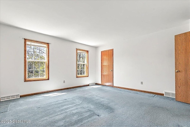 carpeted spare room featuring baseboards and visible vents