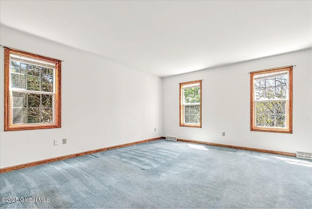 carpeted spare room with visible vents and baseboards