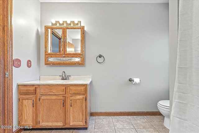 bathroom with baseboards, tile patterned floors, vanity, and toilet