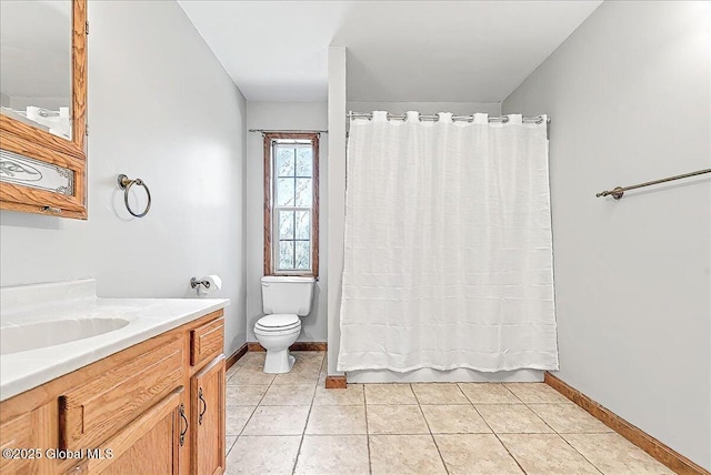 bathroom featuring toilet, baseboards, tile patterned flooring, and vanity