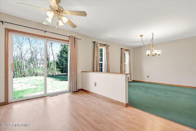 empty room with baseboards, light wood finished floors, and visible vents