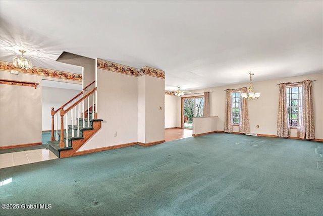 unfurnished living room with carpet floors, baseboards, and an inviting chandelier
