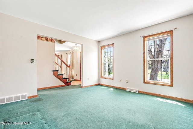 unfurnished living room with visible vents, carpet, and a wealth of natural light