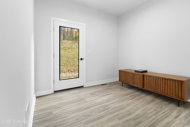 empty room with baseboards, wood finished floors, and visible vents