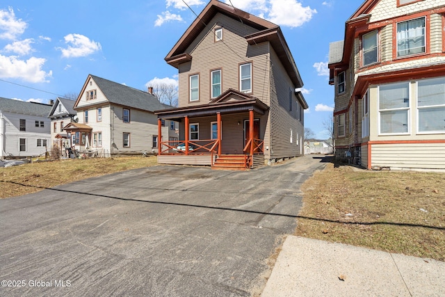 view of front of property featuring a residential view, driveway, and covered porch
