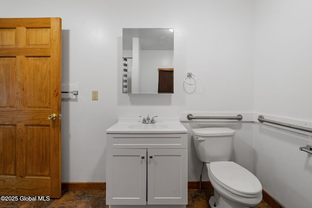 bathroom with baseboards, toilet, and vanity