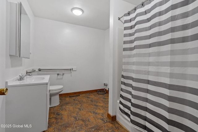 full bath with vanity, toilet, stone finish floor, a shower with shower curtain, and baseboards