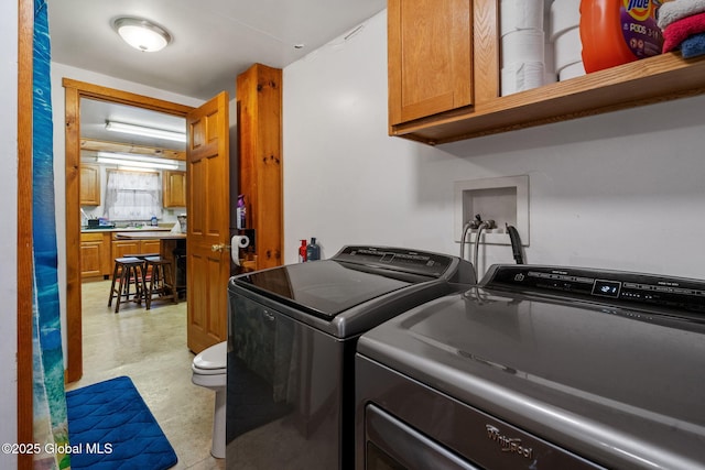 laundry area with washing machine and clothes dryer and light floors