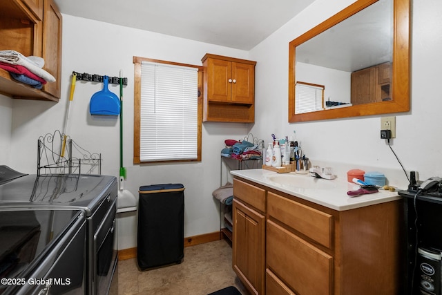 laundry area featuring baseboards, a sink, laundry area, and washer and clothes dryer