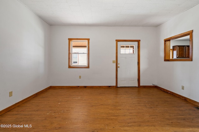 entryway with a wealth of natural light, wood finished floors, and baseboards