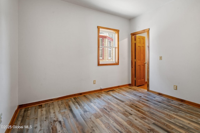 empty room with baseboards and wood finished floors