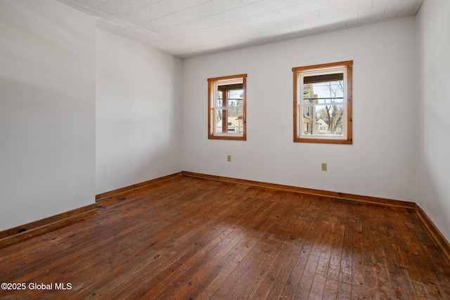 spare room with hardwood / wood-style flooring and baseboards