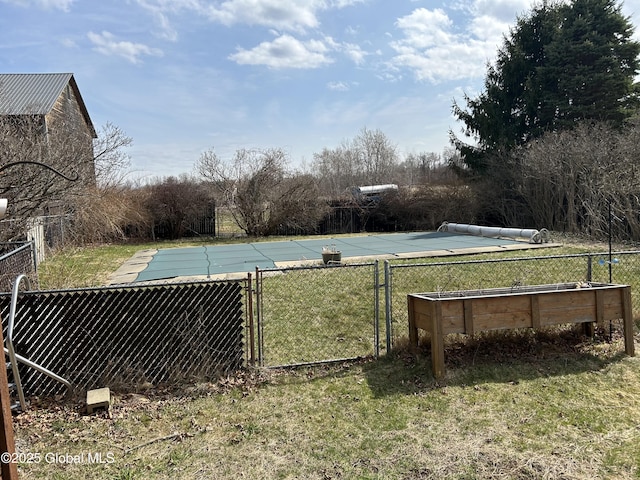 view of swimming pool with fence and a yard