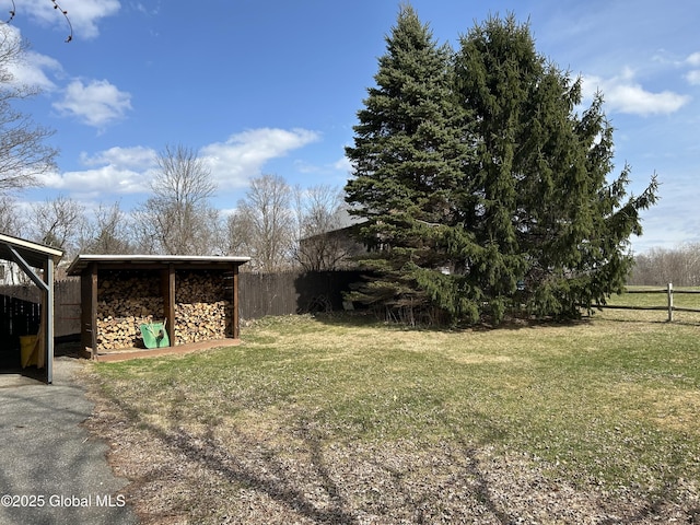 view of yard featuring an outdoor structure and fence