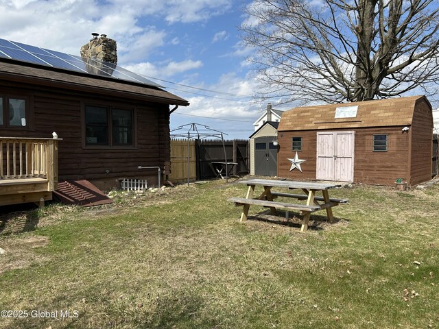 view of yard featuring fence, an outdoor structure, and a storage shed