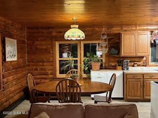 dining space featuring log walls and wood ceiling