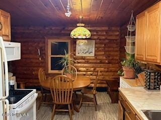 dining space featuring wooden ceiling, wood finished floors, and log walls