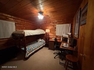 bedroom featuring wood ceiling and log walls