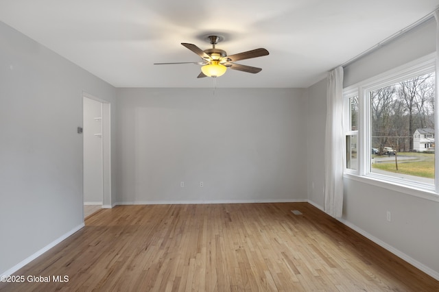 empty room with light wood-style flooring, baseboards, and a ceiling fan