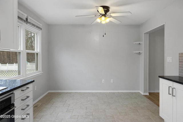 unfurnished dining area featuring visible vents, baseboards, and a ceiling fan