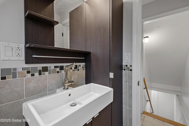 bathroom featuring tile patterned floors, decorative backsplash, a sink, and tile walls