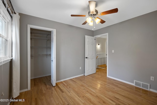 unfurnished bedroom with a closet, light wood-type flooring, baseboards, visible vents, and ceiling fan
