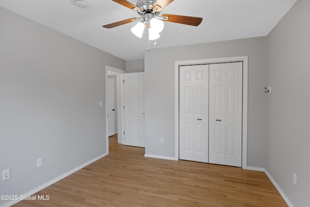 unfurnished bedroom featuring a closet, light wood-style flooring, ceiling fan, and baseboards