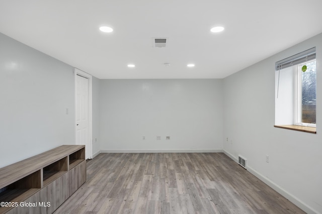 spare room with light wood-type flooring, baseboards, and visible vents