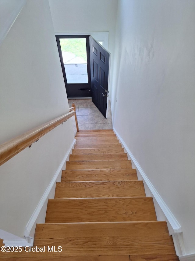 staircase featuring baseboards and tile patterned flooring