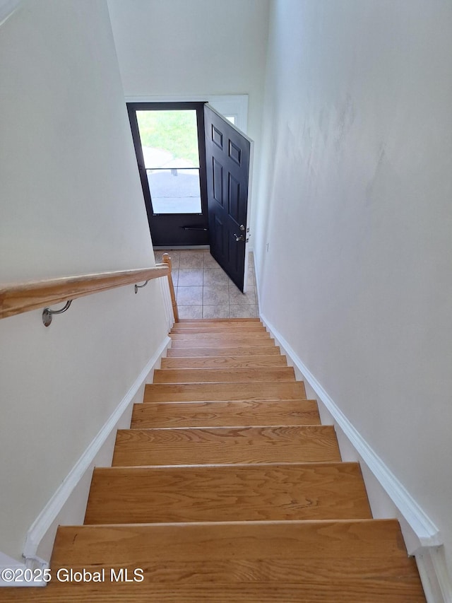 stairway with tile patterned flooring and baseboards
