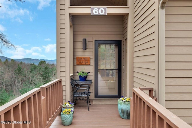 view of exterior entry with a balcony and a mountain view