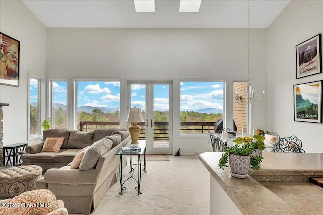 living area with light colored carpet, french doors, and a towering ceiling