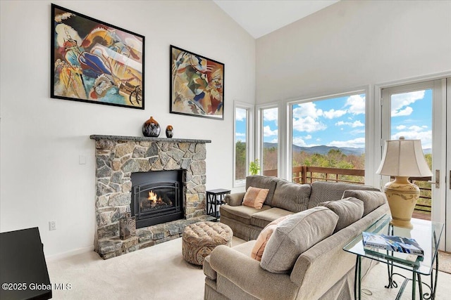carpeted living room featuring baseboards, a fireplace, high vaulted ceiling, and a healthy amount of sunlight
