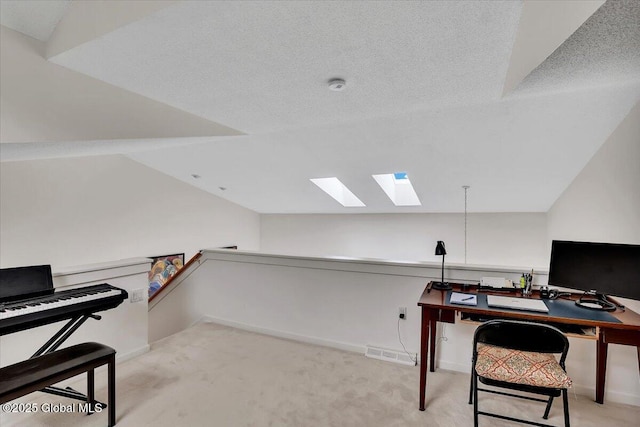office space with lofted ceiling with skylight, carpet, a textured ceiling, and baseboards