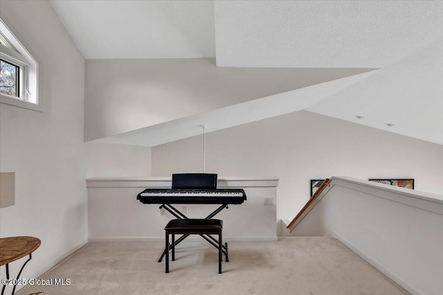 sitting room featuring carpet floors, lofted ceiling, an upstairs landing, and baseboards