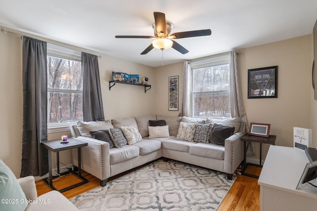 living area featuring light wood-style floors and ceiling fan