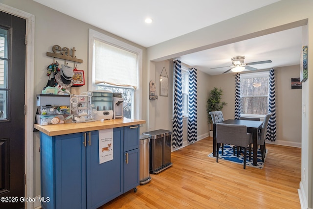 kitchen featuring ceiling fan, wooden counters, blue cabinets, light wood-style floors, and recessed lighting