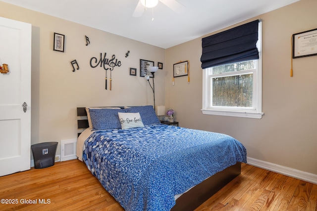 bedroom with visible vents, baseboards, ceiling fan, and wood finished floors