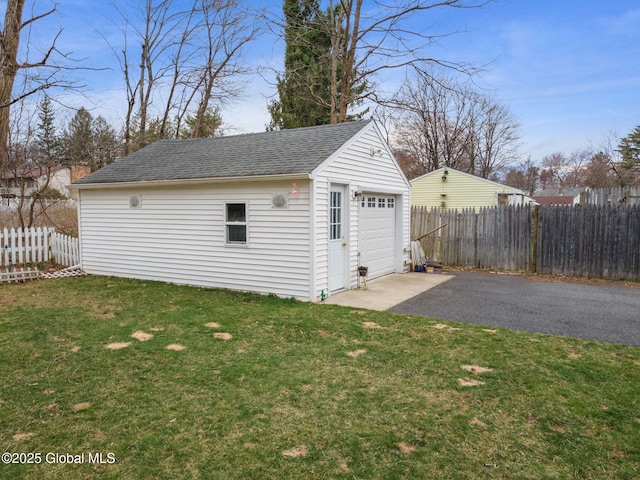 detached garage with fence and driveway