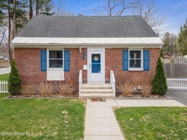bungalow with brick siding, roof with shingles, and fence