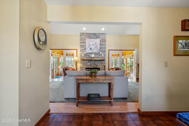 living area with baseboards, a fireplace, and recessed lighting