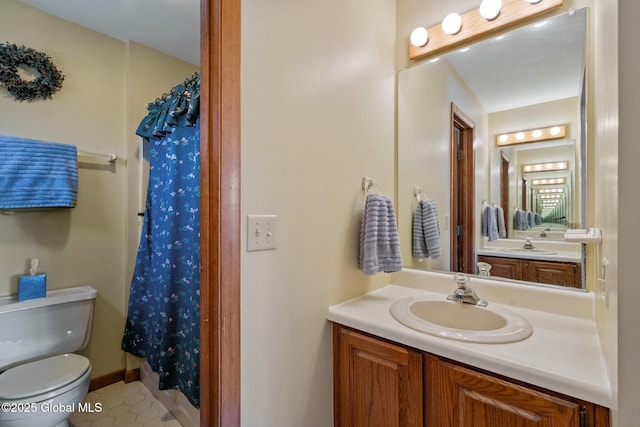 full bathroom with toilet, a shower with curtain, baseboards, and vanity
