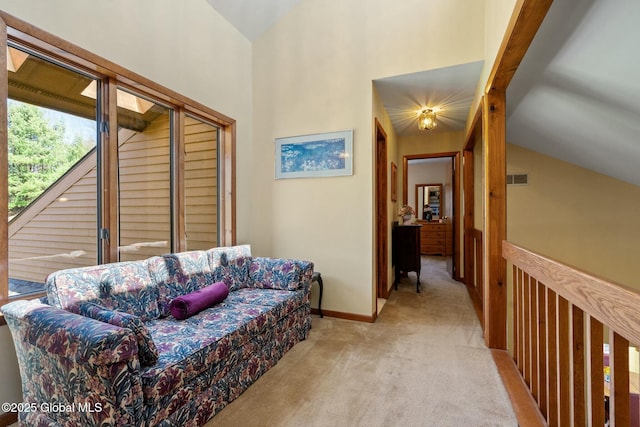 living area featuring baseboards, light colored carpet, visible vents, and high vaulted ceiling