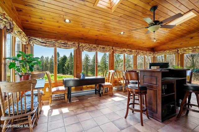 sunroom / solarium with plenty of natural light, wood ceiling, lofted ceiling with skylight, and tile patterned floors
