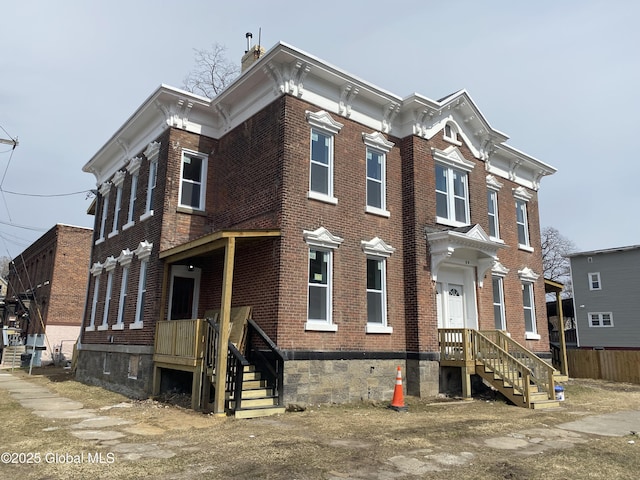 italianate-style house with brick siding and a chimney