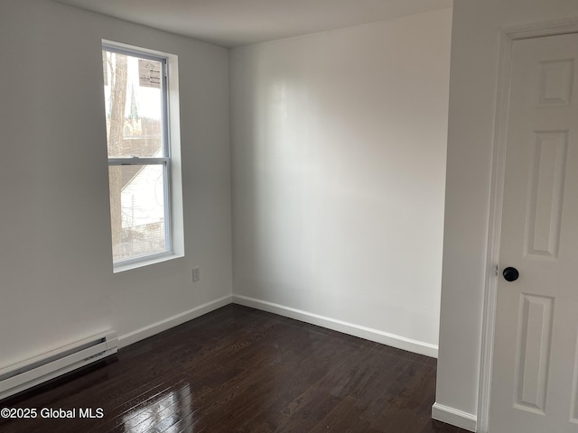 spare room with a baseboard radiator, dark wood-type flooring, and a wealth of natural light