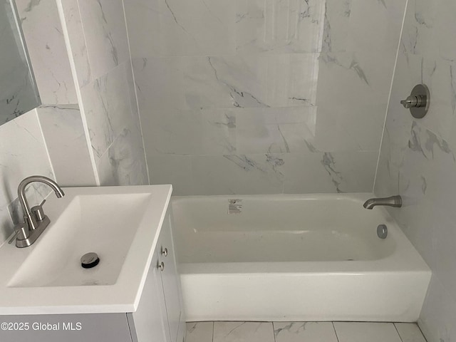 bathroom featuring marble finish floor, tub / shower combination, and vanity