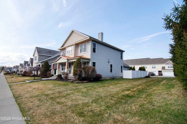 view of side of home with fence, a chimney, a residential view, covered porch, and a yard