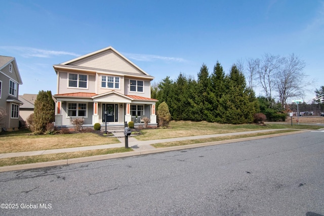 view of front of house with a front lawn, metal roof, a porch, and a standing seam roof