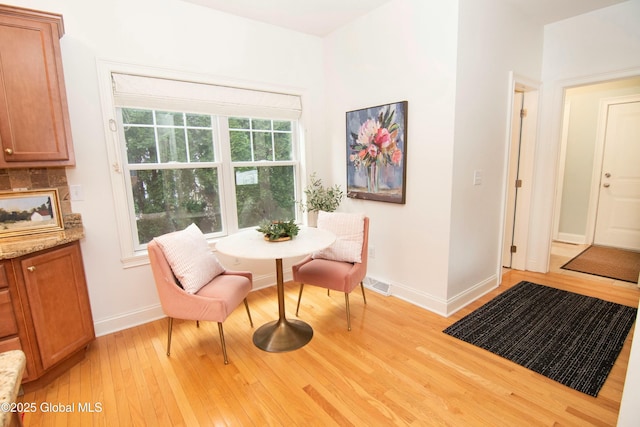dining room with baseboards, visible vents, and light wood-type flooring